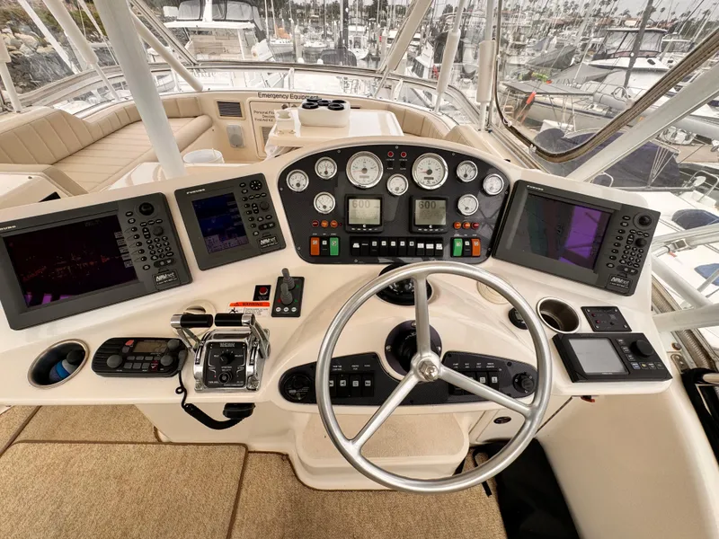 2004 Riviera 47 Flybridge helm with advanced navigation controls and steering wheel.