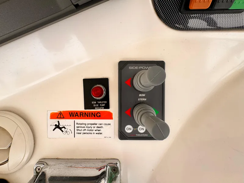 Control panel of 2004 Riviera 47 Flybridge with warning label and joystick controls.