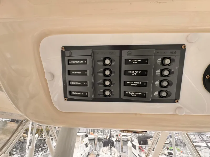 Control panel on a 2004 Riviera 47 Flybridge yacht, featuring various switches and buttons.