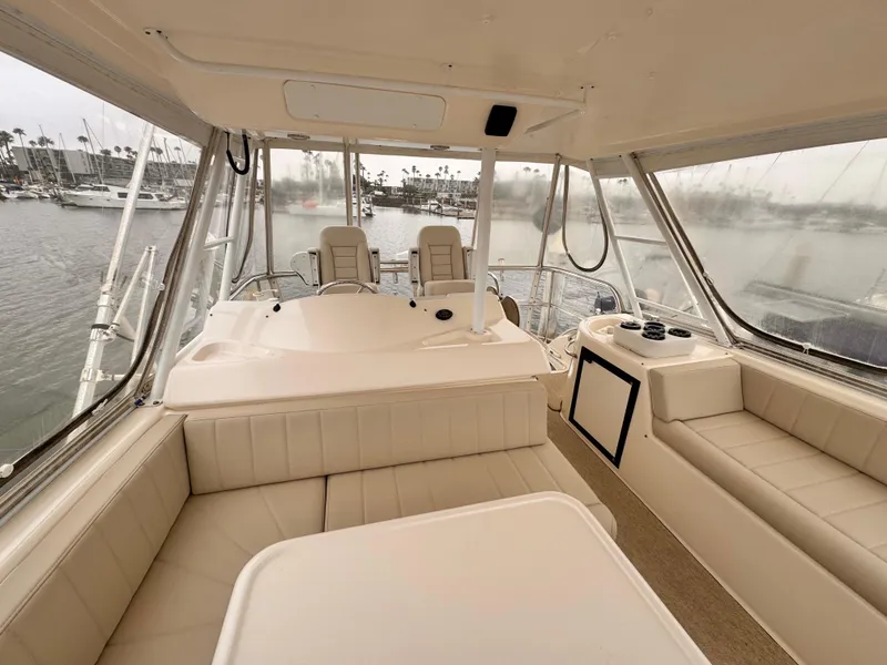 Luxurious interior of 2004 Riviera 47 Flybridge yacht with plush seating and panoramic views.