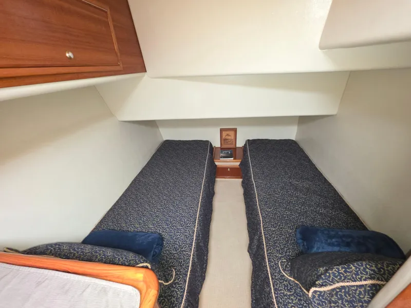 Twin beds in a 2004 Riviera 47 Flybridge cabin with blue bedding.