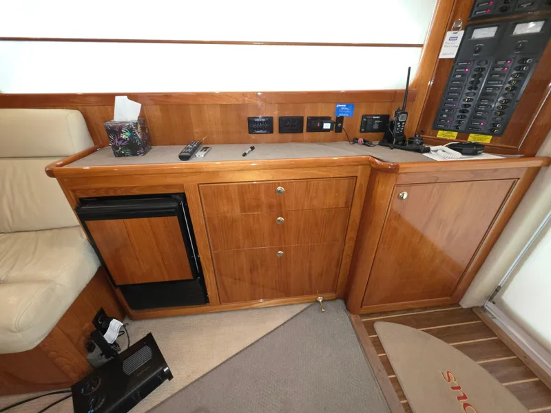 2004 Riviera 47 Flybridge interior with wooden cabinetry and control panel.
