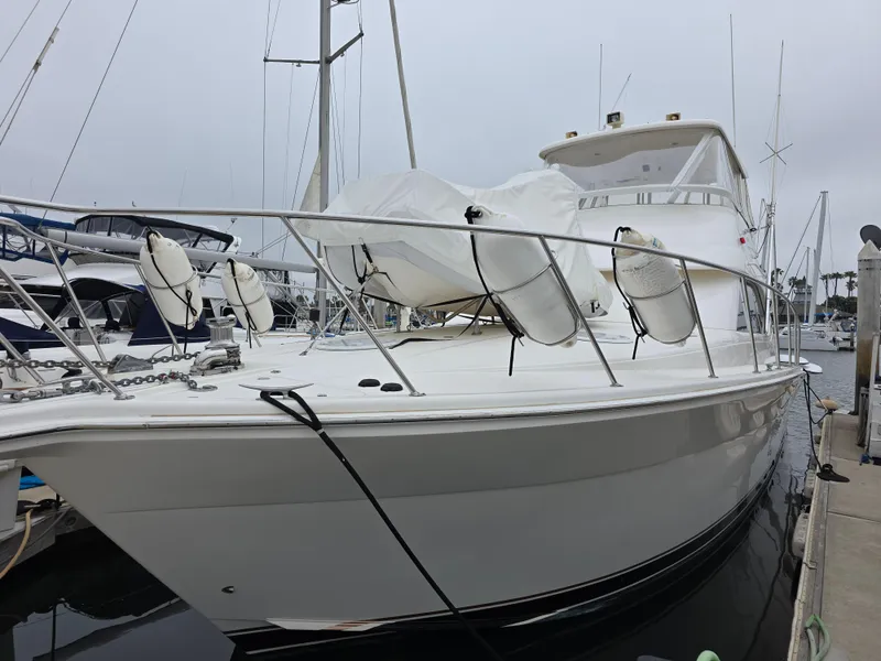 2004 Riviera 47 Flybridge yacht docked at marina, featuring sleek design and spacious deck.