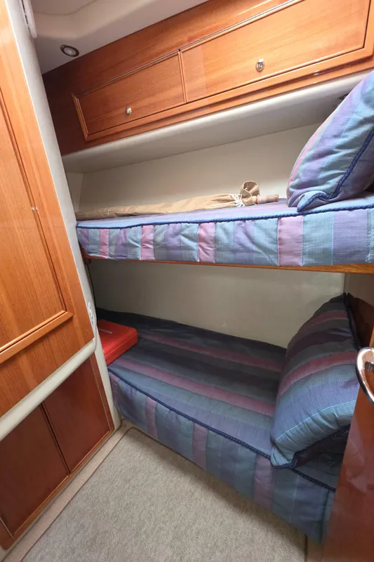 Bunk beds in 2004 Riviera 47 Flybridge yacht cabin with wooden storage cabinets.