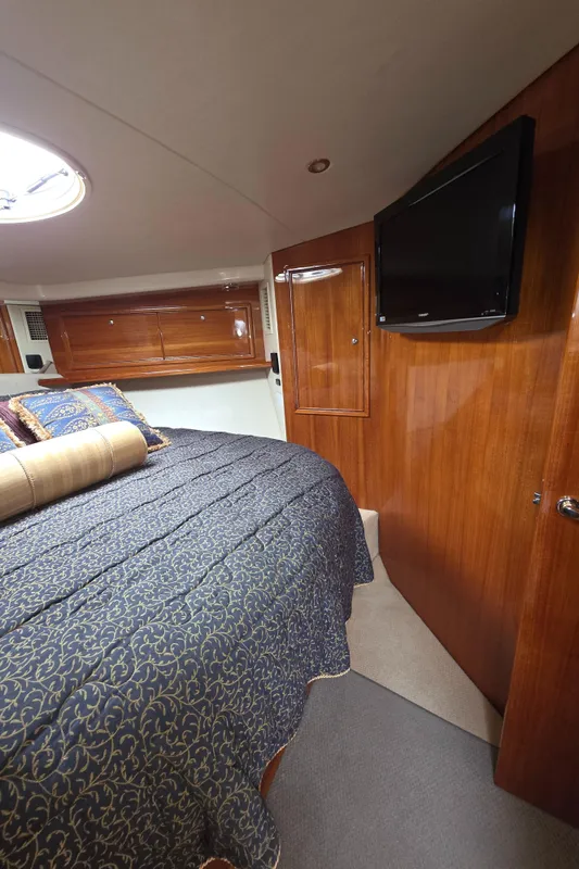 Luxurious cabin interior of 2004 Riviera 47 Flybridge yacht with elegant wood finish.