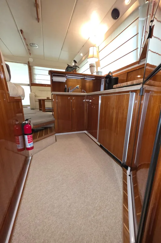 2004 Riviera 47 Flybridge yacht interior with wooden cabinetry and modern kitchen amenities.