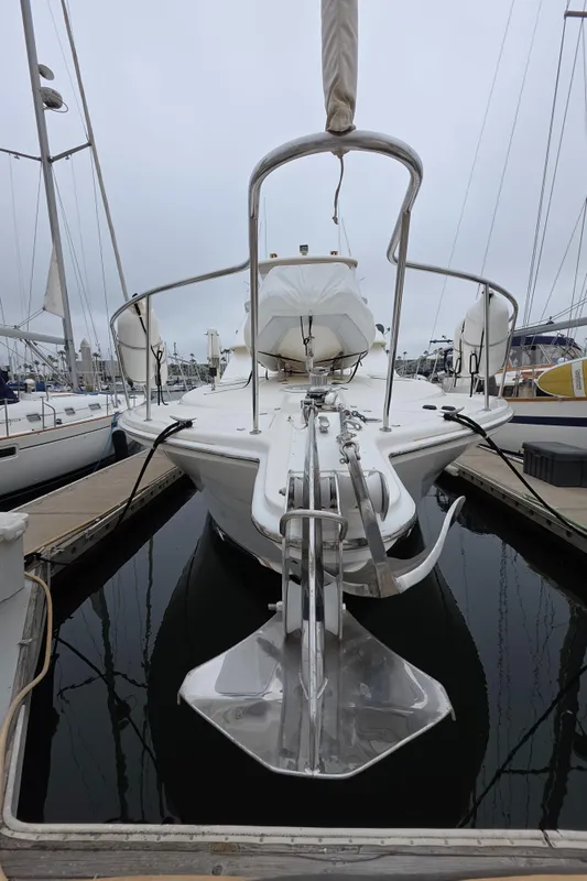 2004 Riviera 47 Flybridge yacht docked, showcasing sleek design and anchor in marina setting.