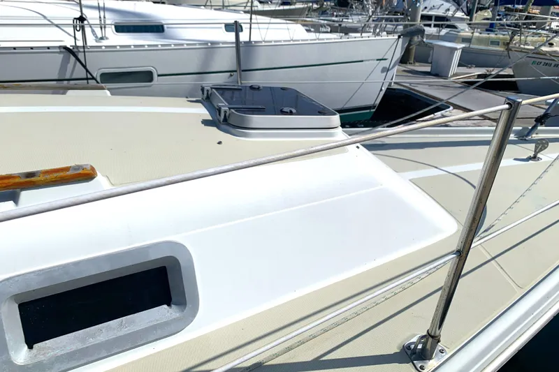 1984 Ericson 30 Plus sailboat deck with hatch and railing in marina.