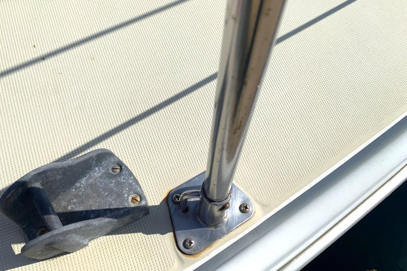 Deck of 1984 Ericson 30 Plus sailboat with metal railing and cleat.