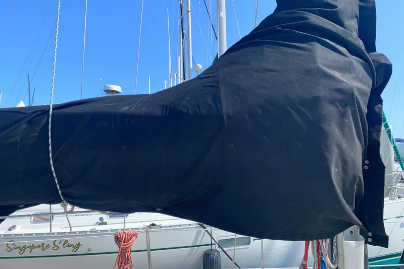 Sailboat with black sail cover, Ericson 30 Plus, 1984 model, docked in marina.