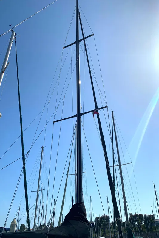 1984 Ericson 30 Plus sailboat mast against clear blue sky.