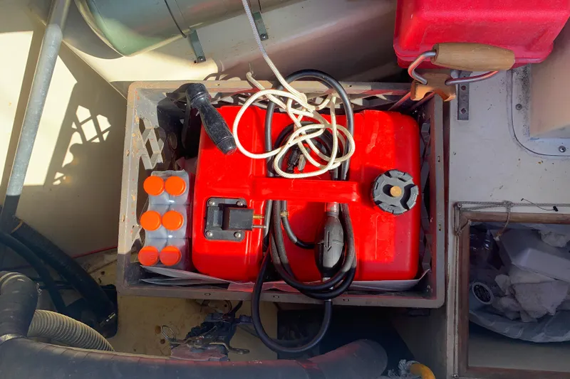 Red fuel tank and cables in 1984 Ericson 30 Plus boat compartment.