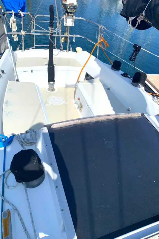 1984 Ericson 30 Plus sailboat cockpit with ropes and equipment, docked on calm water.