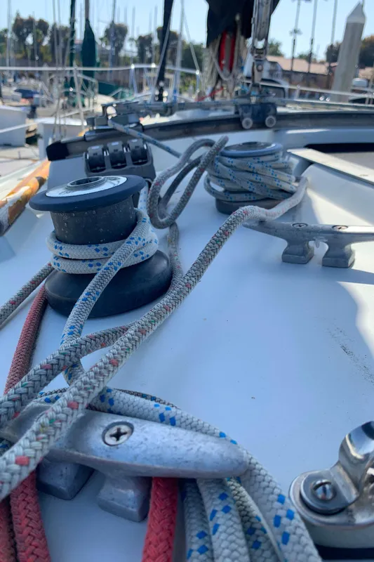 Close-up of 1984 Ericson 30 Plus sailboat deck with ropes and winch.
