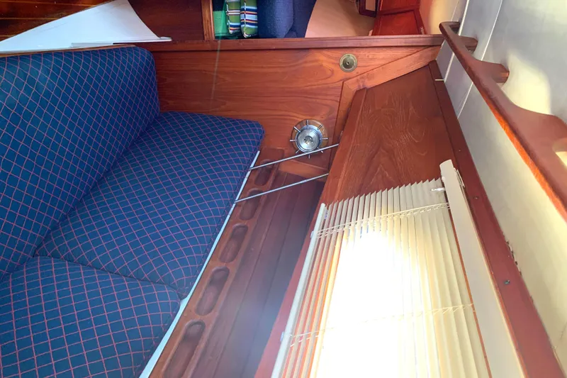 Interior of 1984 Ericson 30 Plus sailboat with blue checkered seating and wooden accents.