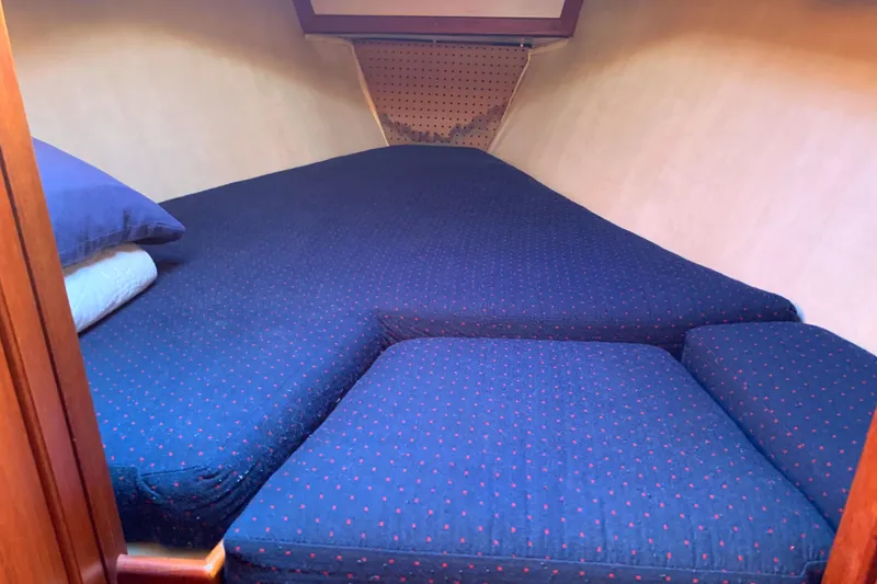 1984 Ericson 30 Plus sailboat cabin with blue bedding and wooden accents.