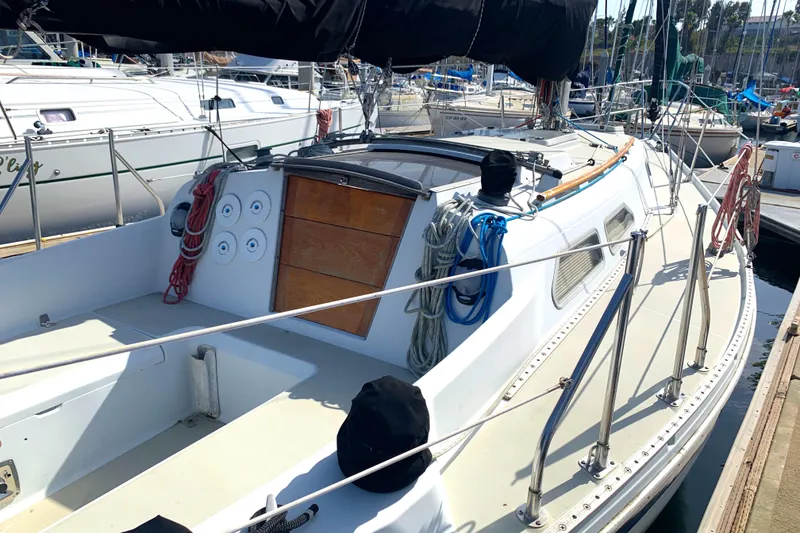 1984 Ericson 30 Plus sailboat docked at marina, featuring spacious deck and rigging.