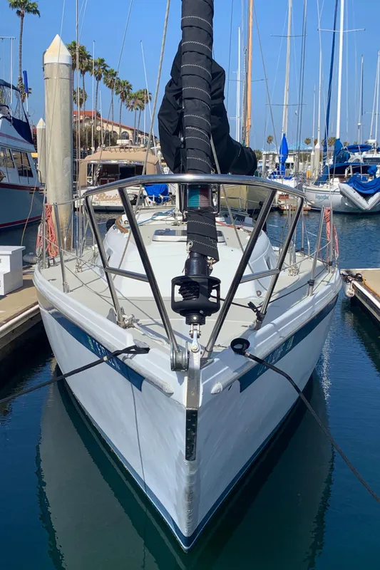 1984 Ericson 30 Plus sailboat docked in a marina, front view.