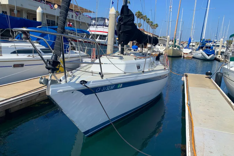 1984 Ericson 30 Plus sailboat docked in a marina, surrounded by other boats.