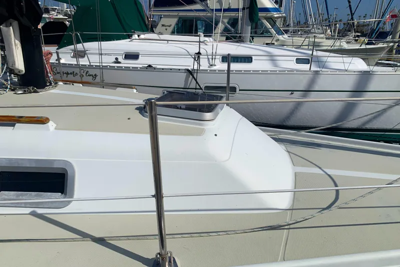 1984 Ericson 30 Plus sailboat docked in a marina, surrounded by other boats.