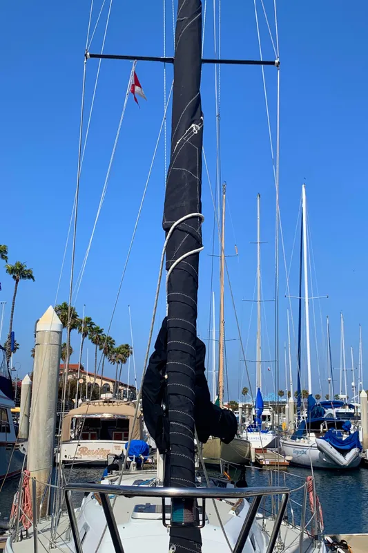 1984 Ericson 30 Plus sailboat docked at a marina with clear blue skies.