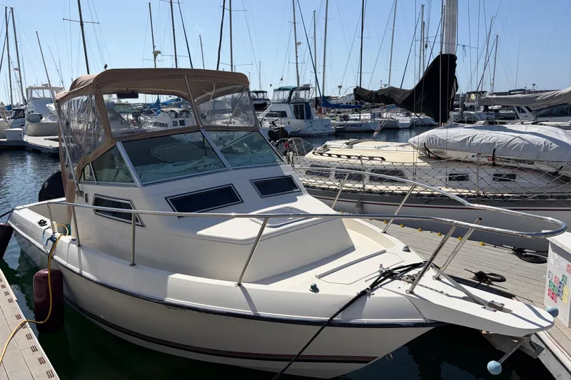 1991 Donzi 255 LXC boat docked in a marina, surrounded by other vessels.