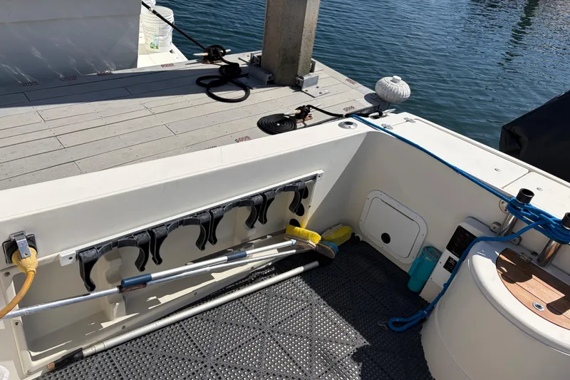 1991 Donzi 255 LXC boat deck with fishing rod holders and dock view.