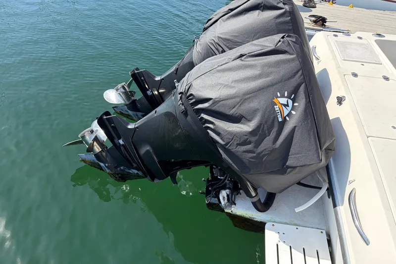 Twin outboard motors on a 1991 Donzi 255 LXC boat, covered and docked.