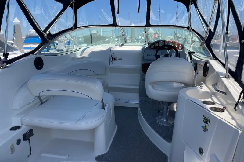 Interior of a 2008 Bayliner 265 boat with white seating and steering console.