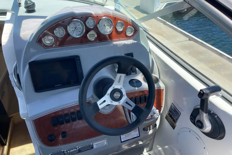 Cockpit of 2008 Bayliner 265 boat with steering wheel and control panel.