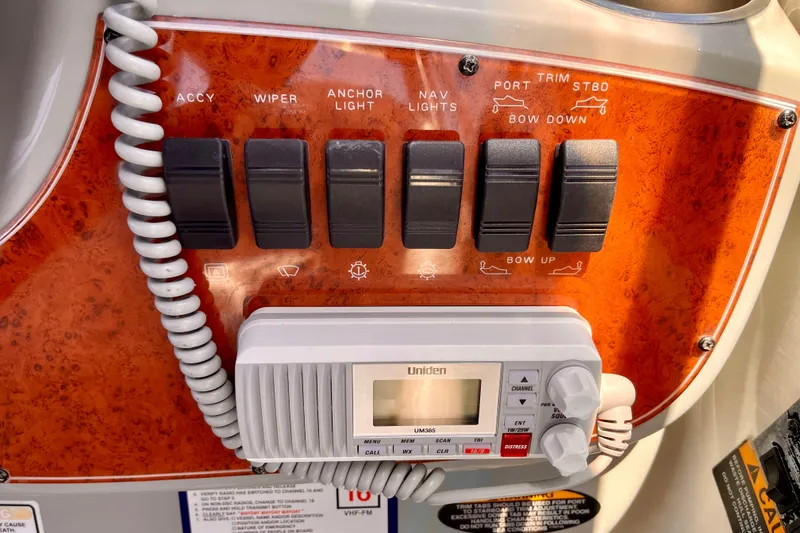 Control panel of a 2008 Bayliner 265 boat with switches and a Uniden radio.