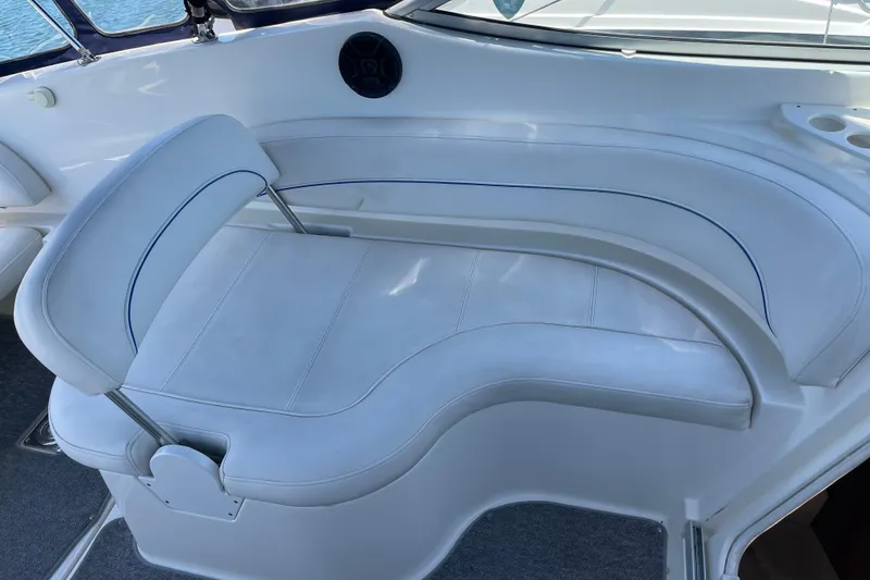 2008 Bayliner 265 boat interior with white cushioned seating and cup holders.