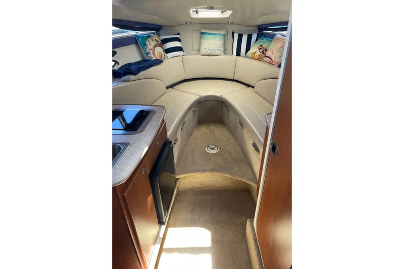 Interior of 2008 Bayliner 265 boat with cozy seating and kitchenette.