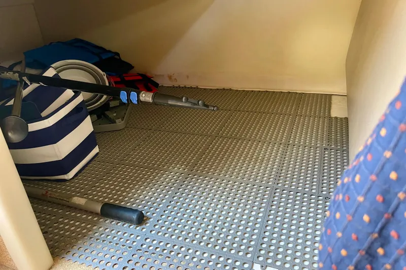 Storage area in a 2008 Bayliner 265 boat with fishing gear and life jackets.