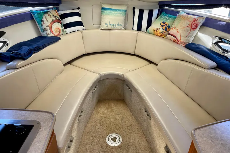 Interior of 2008 Bayliner 265 boat with cozy seating and decorative pillows.