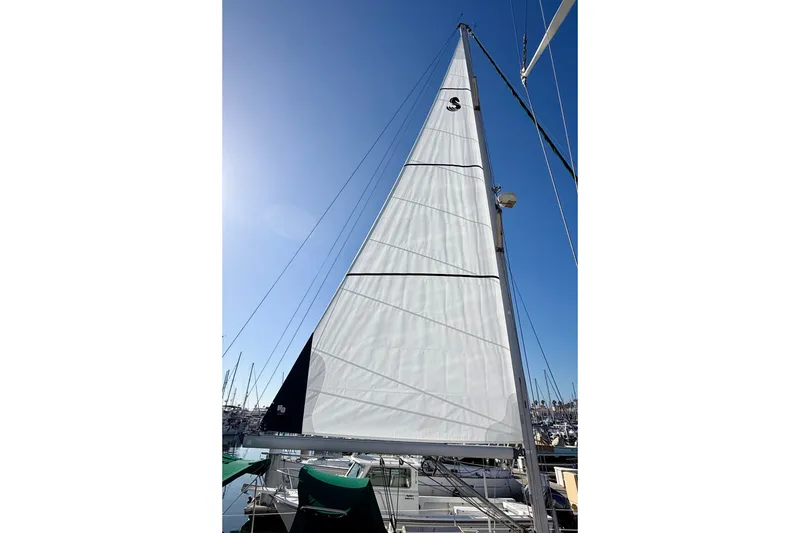 Sail of a 2001 Beneteau 411 yacht against a clear blue sky.