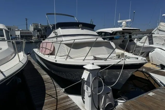 1972 Luhrs 32 Convertible boat docked at marina under clear blue sky.