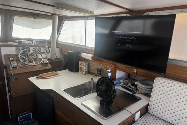Interior of a 1972 Luhrs 32 Convertible boat with helm, sink, and TV.