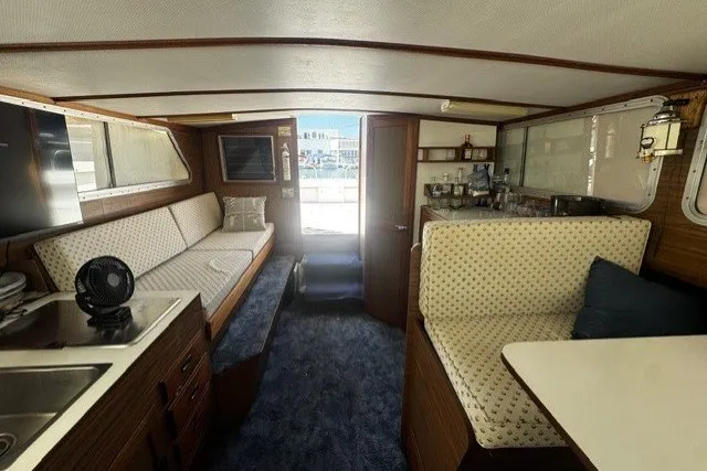 Interior of a 1972 Luhrs 32 Convertible boat with seating and kitchenette.