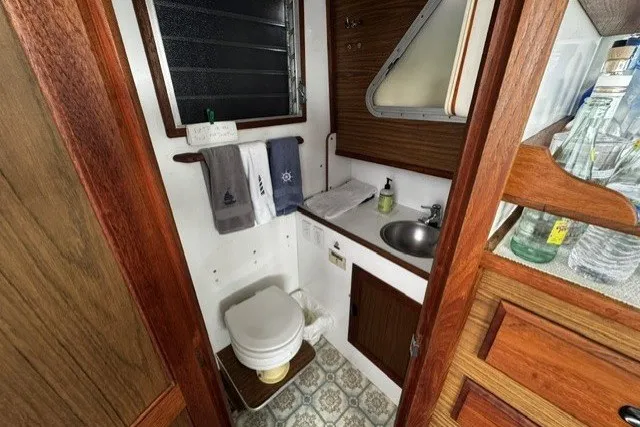 1972 Luhrs 32 Convertible boat bathroom with wooden accents and compact sink area.