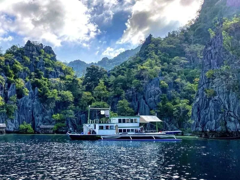 Phinisi Custom Pleasure Cruiser 2016 in scenic tropical bay with lush cliffs.