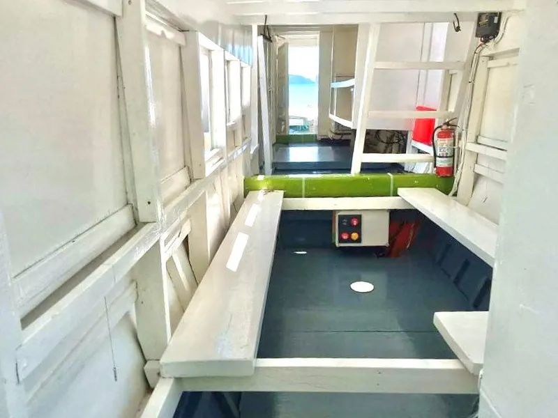 Interior of 2016 Phinisi Custom Pleasure Cruiser or Dive Boat with white benches and safety equipment.