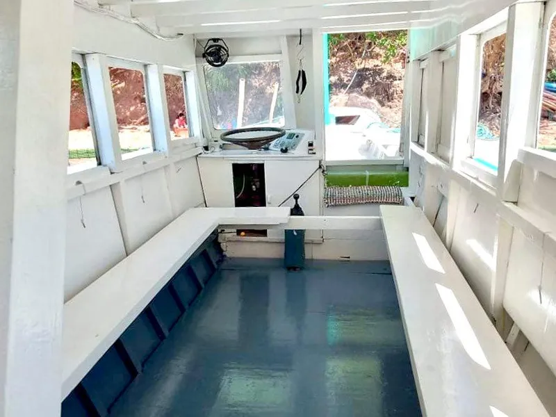 Interior of 2016 Phinisi Custom Pleasure Cruiser or Dive Boat with white benches and windows.