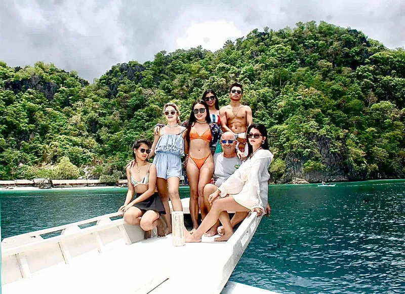 Group enjoying on Phinisi Custom Pleasure Cruiser, 2016, with lush green island backdrop.