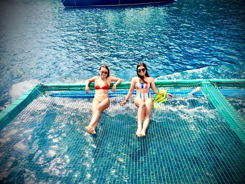 Two women relaxing on a Phinisi Custom Pleasure Cruiser net, 2016 model.