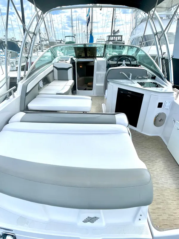 2016 Four Winns 255 Vista boat interior with seating, kitchenette, and helm, docked at marina.
