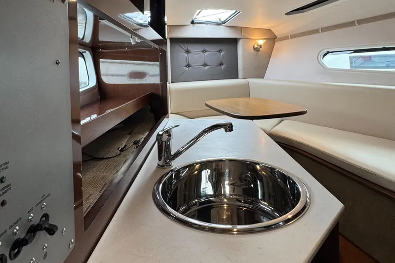 Interior of 2016 Four Winns 255 Vista boat with kitchenette and seating area.