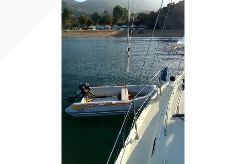 Sailboat view from Pacific Seacraft Dana 24, 2002, with dinghy on calm water.