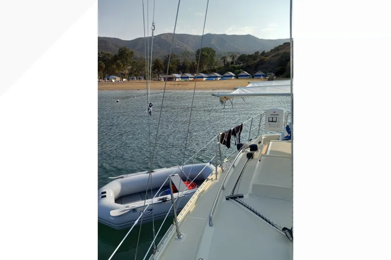 Sailboat Pacific Seacraft Dana 24, 2002, anchored near a scenic beach with mountains.