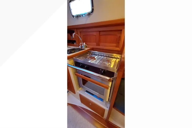 Compact galley kitchen in 2002 Pacific Seacraft Dana 24 sailboat with stove and sink.